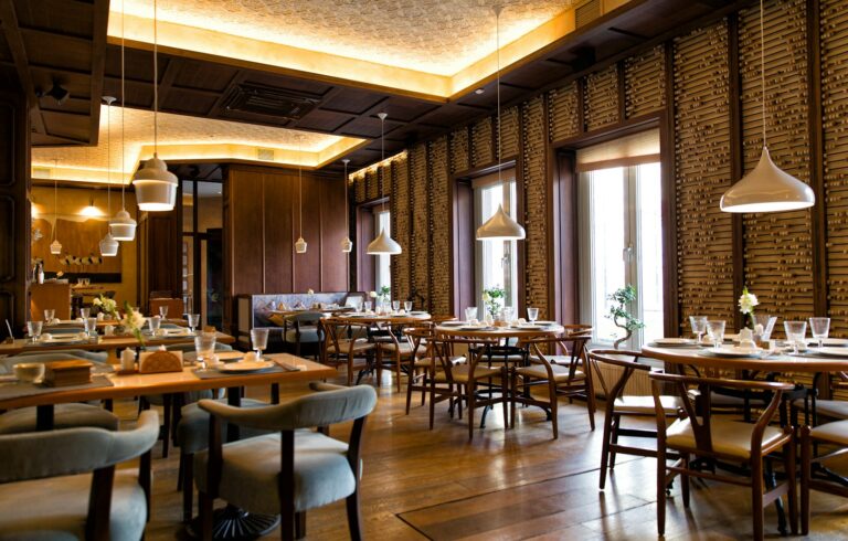 Lys restaurant med trebord og varm belysning (illustrasjonsfoto)